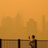 New York, USA.  Eine Frau schützt sich mit einer Maske vor dem Schleier, der die US-Metropole benebelt. Wegen der heftigen Waldbrandsaison in diesem Jahr, hat sich der Dunst über die kanadische Grenze hinweg ausgebreitet. Dadurch schossen auch die Smogwerte in die Höhe: Laut Klimaforscher Marschall Burke von der Stanford University soll die Luftbelastung die zwischen 2006 und 2022 gemessenen Höchstwerte überschritten haben.
