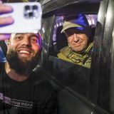 Ein Mann macht ein Selfie mit Wagner Söldner Jewgenij Prigoschin der in einem Auto sitzt in Tarnkleidung