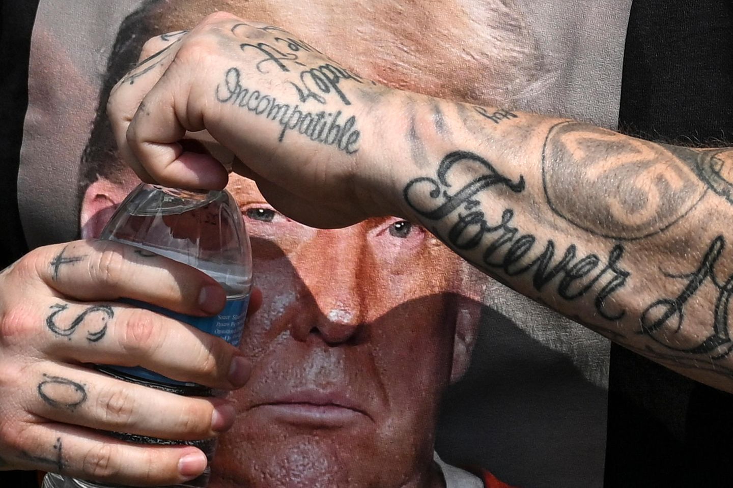 USA Ein Mann mit einem Trump T-Shirt öffnet eine Wasserflasche