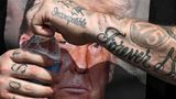 Ein Mann mit einem Trump T-Shirt öffnet eine Wasserflasche