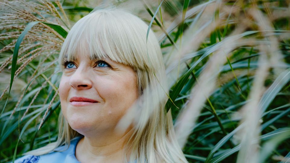 Melodie Michelberger in blauer Bluse vor Schilf
