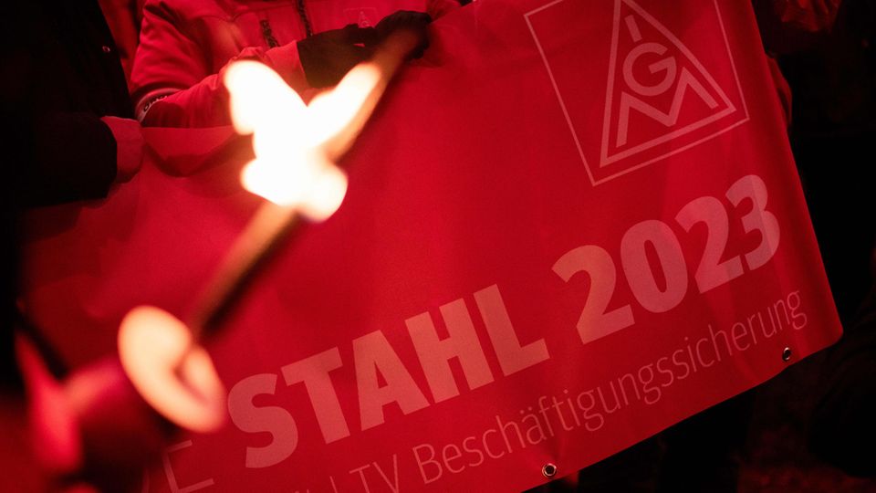 Demonstranten halten ein Banner mit der Aufschrift "Stahl 2023" während eines Protests im Tarifstreit der IG Metall