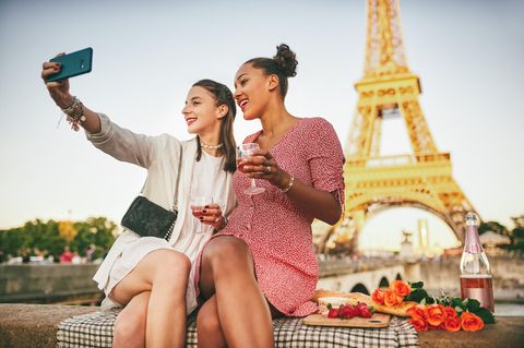 Zwei Frauen machen ein Selfie vor dem Eiffelturm