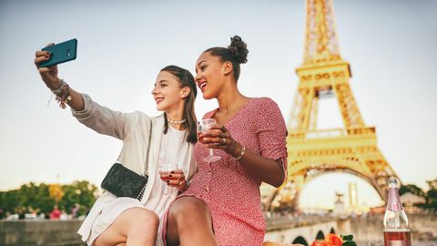 Zwei Frauen machen ein Selfie vor dem Eiffelturm