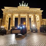 Die ersten sind bereits in der Nacht angerollt: Fünf Traktoren parken als Zeichen des Protests vor dem erleuchteten Brandenburger Tor in Berlin.