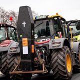Andere machen ihrem Ärger auch ohne Worte Luft. Dieser gelbe Traktor transportiert einen Grabstein mit der Aufschrift: "Stirbt der Bauer, stirbt das Land".
