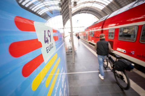 Menschen stehen am Bahnsteig am Hauptbahnhof vor einem Zug
