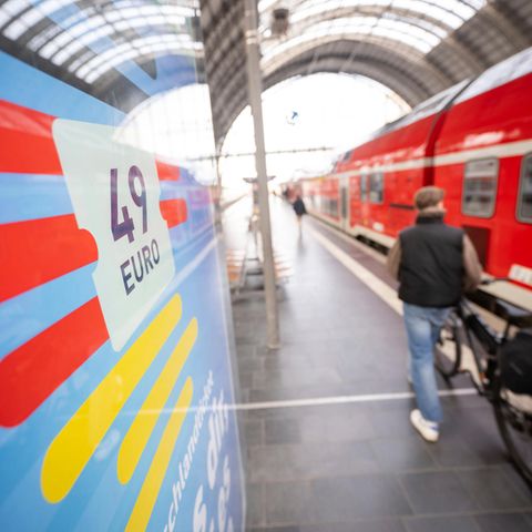 Menschen stehen am Bahnsteig am Hauptbahnhof vor einem Zug