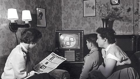 Zwei Frauen und ein kleiner Junge vor einem der ersten Fernsehapparate