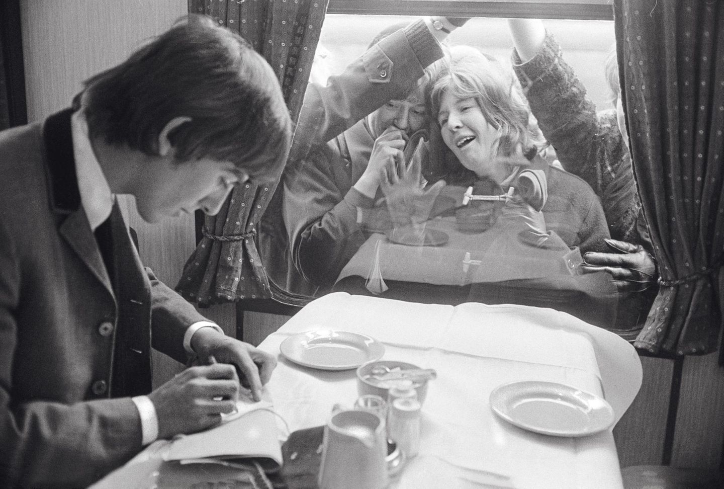 1964 - Großbritannien Beatlemania Die Beatles bekommen ihren eigenen Zug – für den Film „A Hard Days Night“, der einen Tag in ihrem Leben beschreibt. Weltweit schmelzen die jungen Leute ihretwegen dahin, wie hier der Fan in London vor dem Speisewagen beim Anblick von George Harrison. In den amerikanischen Billboard-Charts belegen die Beatles im April mal eben die ersten fünf Plätze – mit „Can’t Buy Me Love“, „Twist And Shout“, „She Loves You“, „I Want To Hold Your Hand“ und „Please Please Me“.