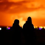 Menschen beobachten, wie der Nachthimmel nach dem Ausbruch eines Vulkans