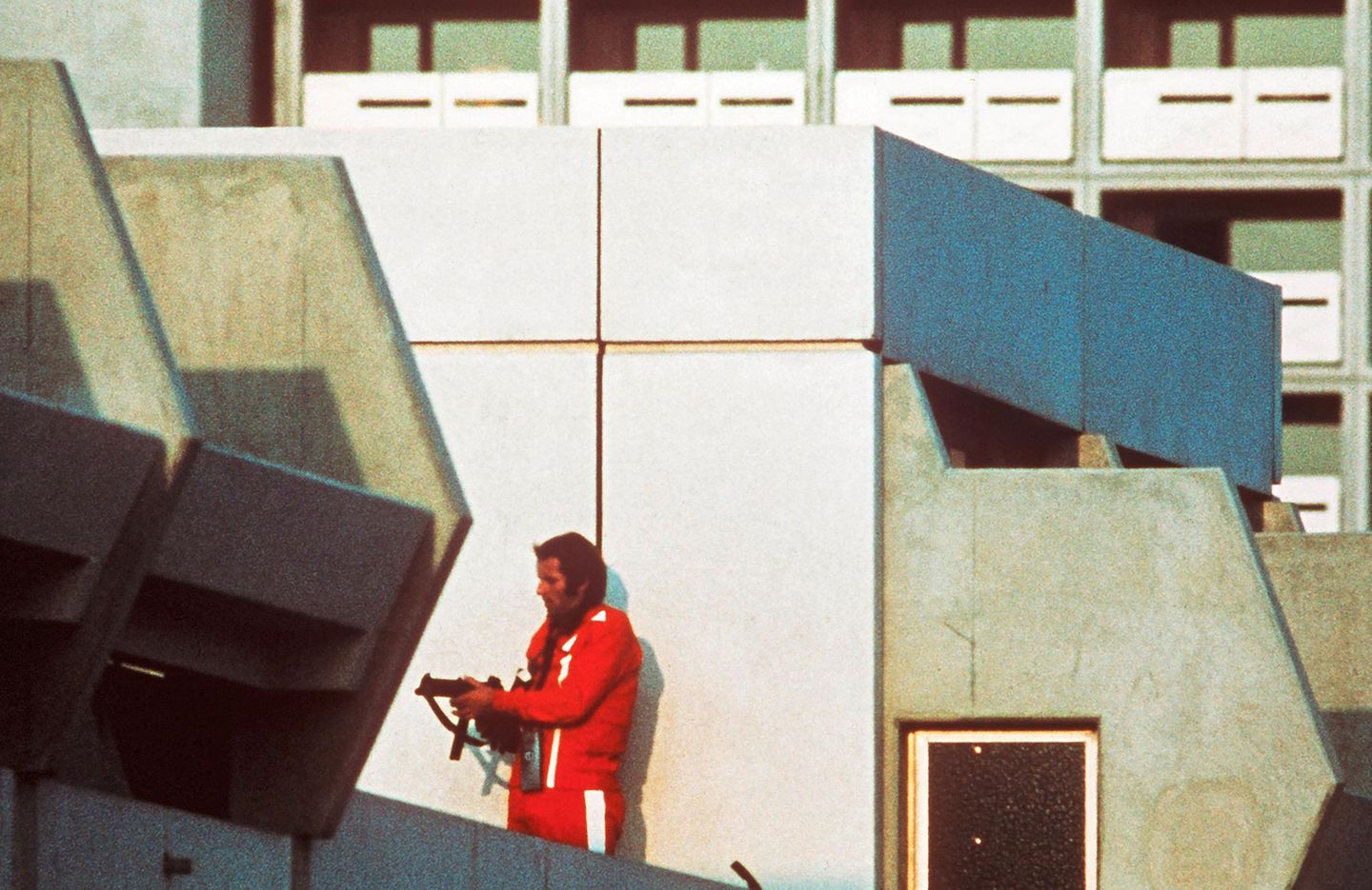 1972 - München Blutige Spiele Der bewaffnete Polizist trägt einen Trainingsanzug. Er sichert an diesem 5. September im olympischen Dorf in München jenen Block, in dem palästinensische Terroristen zwei Sportler der israelischen Olympiamannschaft erschossen haben. Die Täter nehmen neun weitere Israelis als Geiseln. Auch diese sterben, als ein Befreiungsversuch auf dem Flughafen Fürstenfeldbruck misslingt. Zudem kommen ein bayerischer Polizist und fünf der acht Attentäter ums Leben. „Heitere Spiele“ wollte Deutschland so gern ausrichten. Davon kann nun keine Rede mehr sein, aber beendet werden die Spiele auch nicht. 2023, mehr als 50 Jahre später, beginnen Forscher mit der wissenschaftlichen Aufarbeitung des Attentats.