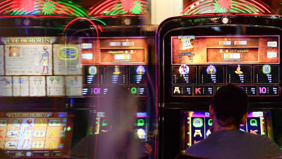 Ein Mann sitzt vor einem Spielautomaten