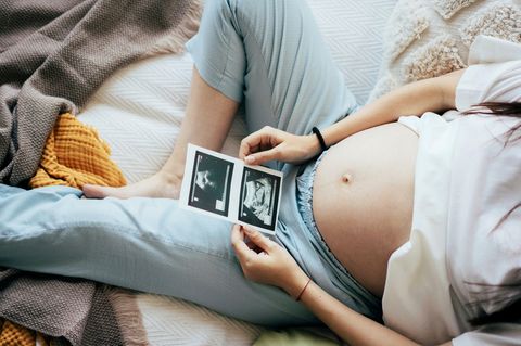 Eine Frau hält ein Ultraschallbild in der Hand