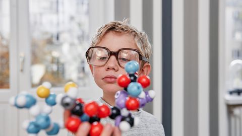 Ein kleiner Junge betrachtet eine Molekularstruktur