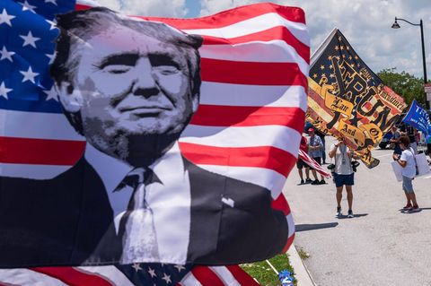 Anhänger von Donald Trump schwenken in Palm Beach, Florida, Fahnen mit dem Konterfei des ehemaligen Präsidenten.