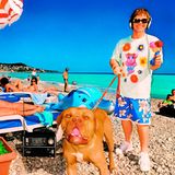 Der junge Elton John mit einem Hund an der Leine am Strand von Nizza