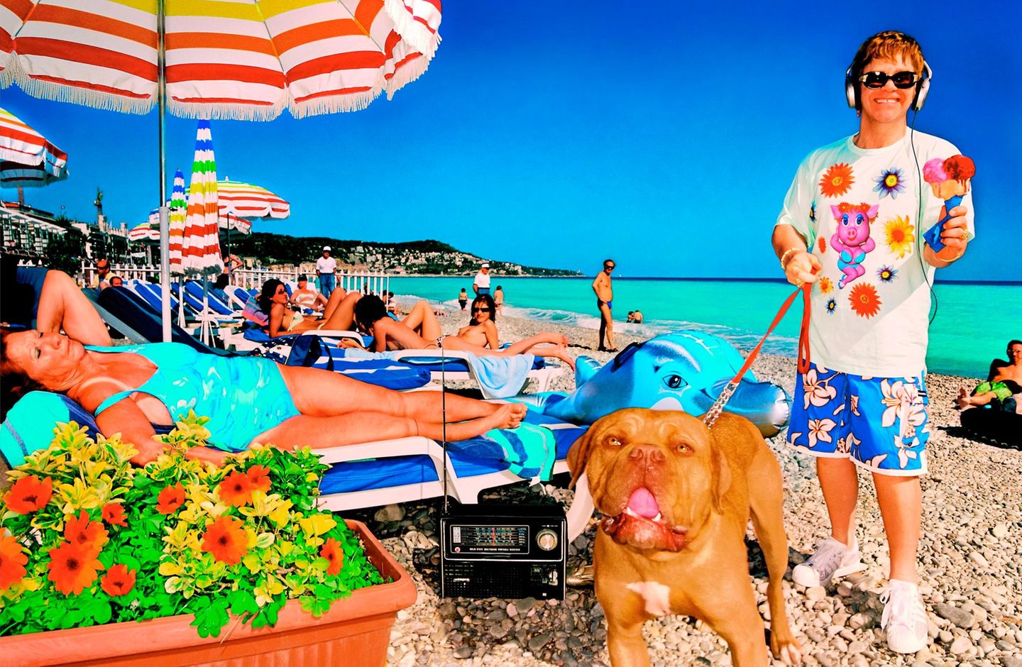 Der junge Elton John mit einem Hund an der Leine am Strand von Nizza
