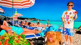 Der junge Elton John mit einem Hund an der Leine am Strand von Nizza