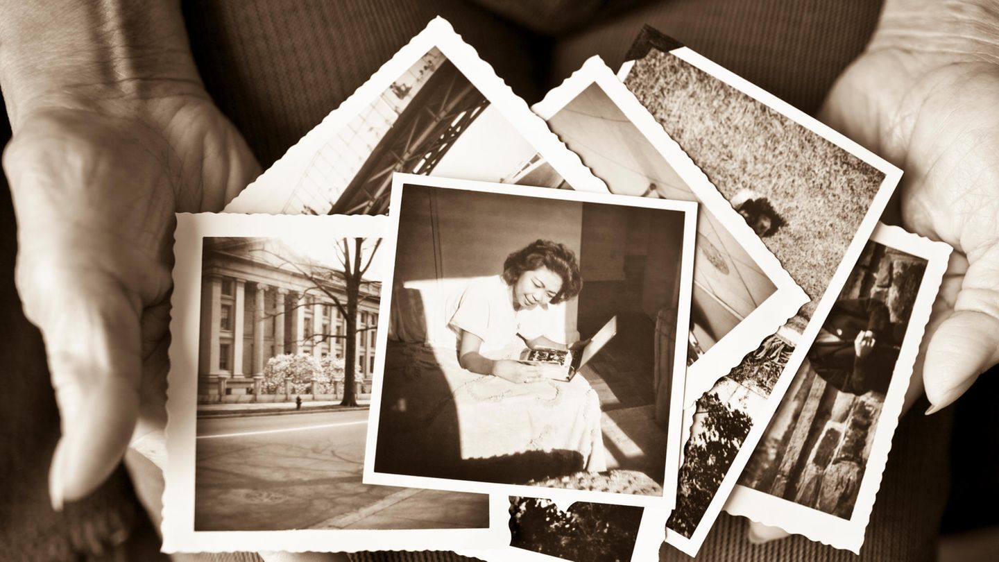 Nostalgie: Alte Fotos liegen in den Händen einer älteren Person