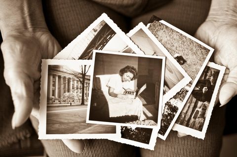 Nostalgie: Alte Fotos liegen in den Händen einer älteren Person