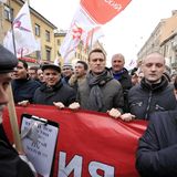 Alexej Nawalny und seine Mitstreiter tragen ein rotes Transparent auf einer Demonstration