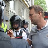 Alexej Nawalny trägt ein Poloshirt, um ihn herum sind Polizisten mit Helmen