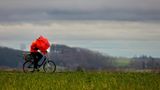 Radfahrer mit Regenschirm