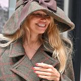 Pamela Anderson im Tweedmantel und mit Hut