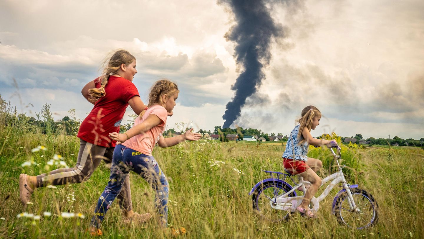 Unter den dunklen Wolken des Krieges übt die fünfjährige Alina, begleitet von Freundinnen, das Fahrradfahren auf einer Wiese im Nordwesten der Ukraine - ein Moment der Unbeschwertheit. In der Nacht zuvor hat eine russische Drohne hier ein Öllager in Brand gesetzt