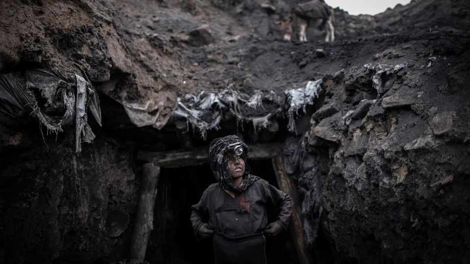 Ein Junge, der als Bergarbeiter arbeitet, steht vor einem informellen Kohlebergwerk in Chinarak in der afghanischen Provinz Baghlan. Hunderte von Bergleuten, von Männern über 60 bis hin zu Jungen im Alter von zehn Jahren, arbeiten jeden Tag in den Minen von Chinarak, die sich mehrere hundert Meter in den Berg bohren, für einen Tageslohn von nur wenigen Euro