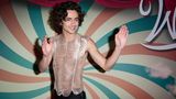 Timothée Chalamet in einem Glitzertop vor bunter Wand