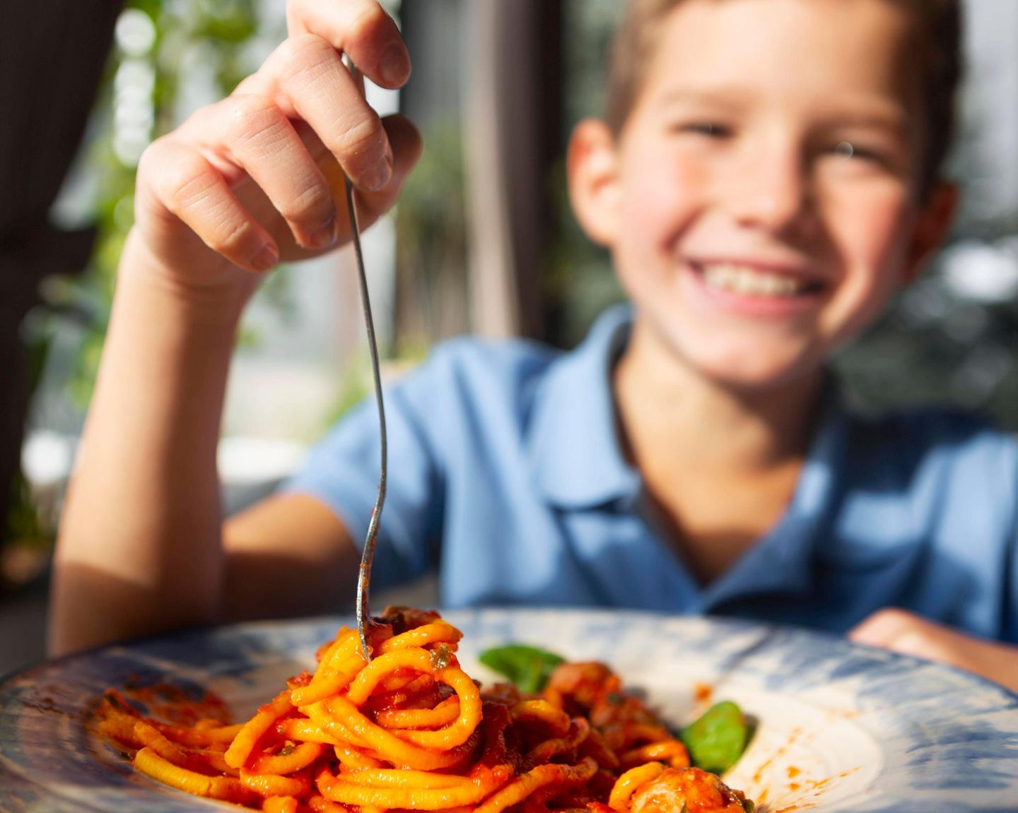 Junge vor Teller mit Spaghetti