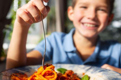 Junge vor Teller mit Spaghetti