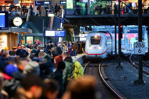 Züge der Deutschen Bahn in einem überfüllten Bahnhof