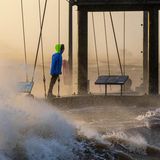 Ein Spaziergänger wagt sich bei Sturmflut und Wellen an das Ufer der Wesermündung in Bremerhaven