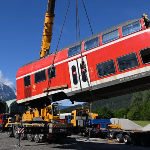 Ein auseinandergeschnittenes Waggonteil wird nach dem Zugunglück von Garmisch-Partenkirchen vom Laster gehoben und gelagert