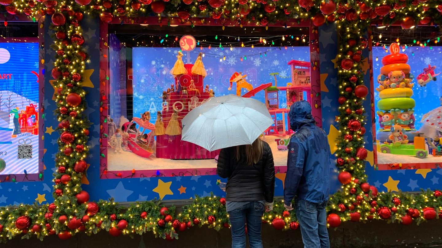 Menschen mit Regenschirmen vor einem Schaufenster in New York
