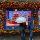 Menschen mit Regenschirmen vor einem Schaufenster in New York