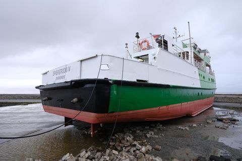 Erst zu viel Wasser, dann an der falschen Stelle: In Neuharlingersiel in Ostfriesland ist die Fähre "Spiekeroog IV" an Land gespült worden und liegt nun auf einem Parkplatz am Fährterminal.