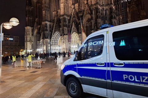 Ein Polizeiauto steht vor dem Kölner Dom – wohl Anschlagspläne