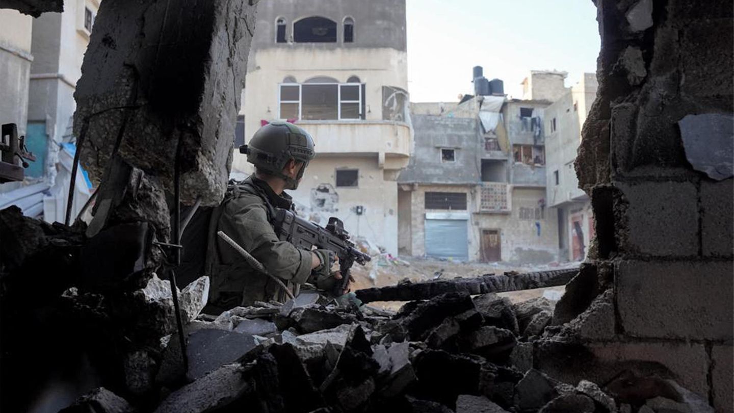 Ein israelischer Soldat läuft mit einem Maschinengewehr durch kaputte Gebäude im Gazastreifen