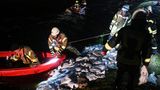 Einsatzkräfte flicken die Löcher im Deich mit gefüllten Sandsäcken