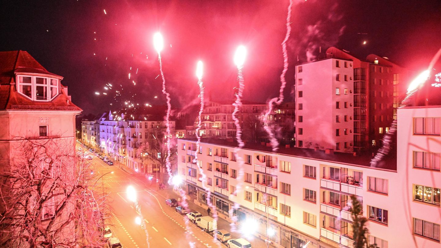 Menschen stehen am 31. Dezember 2022 auf einem Berliner Balkon und feiern den Jahreswechsel