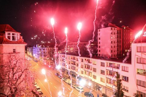 Menschen stehen am 31. Dezember 2022 auf einem Berliner Balkon und feiern den Jahreswechsel