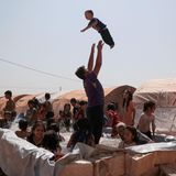 Kinder spielen in einem behelfsmäßigen Pool in einem Lager für Binnenvertriebene