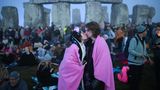 Ein Pärchen küsst sich vor Stonehenge