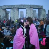 Ein Pärchen küsst sich vor Stonehenge