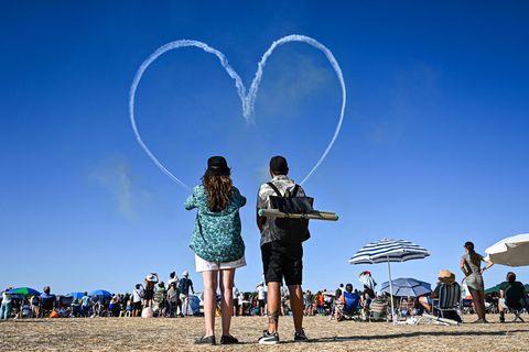 Zauscher sehen ein von einem Kunstflugteam in den Himmel gezeichnetes Herz