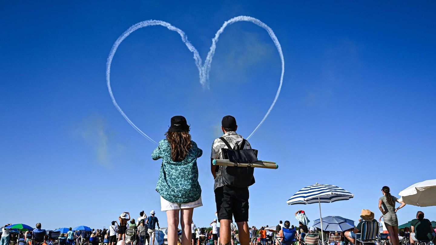 Himmlische Liebe Zauscher sehen ein von einem Kunstflugteam in den Himmel gezeichnetes Herz